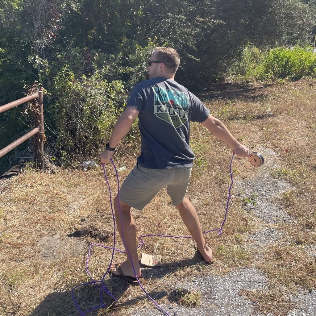 A person magnet fishing with a magnet fishing kit